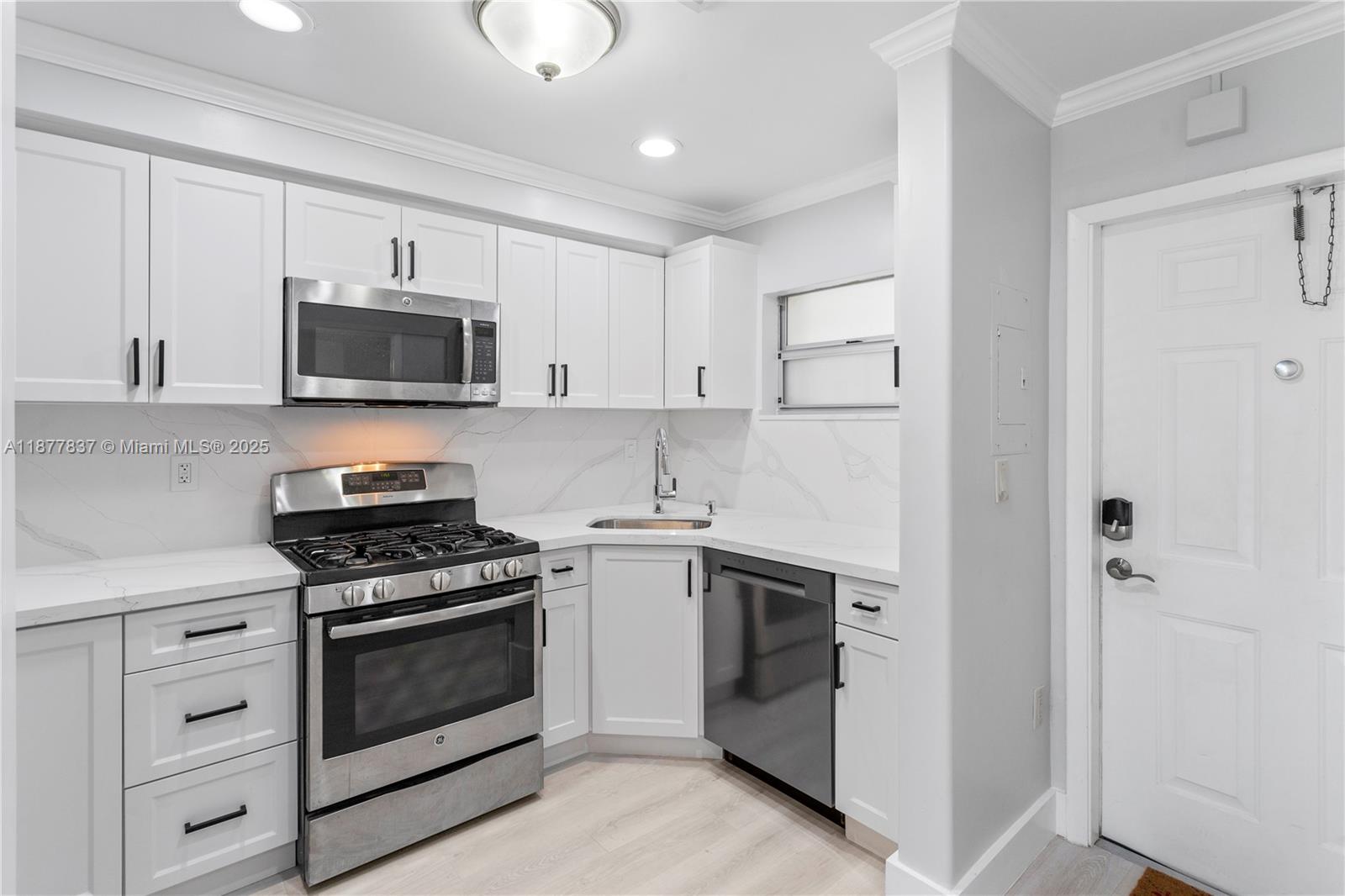 8600 Southwest 67th Avenue, Unit 937 Pinecrest, FL 33156 - Photo 21 of 24 a kitchen with white cabinets and stainless steel appliances