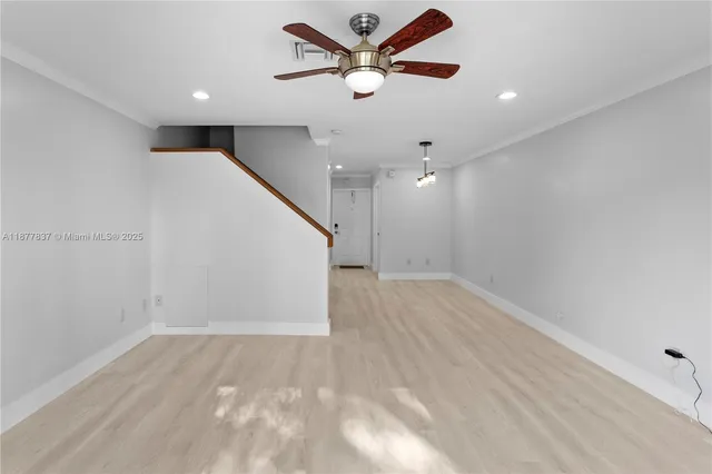 wooden floor in an empty room with a ceiling fan