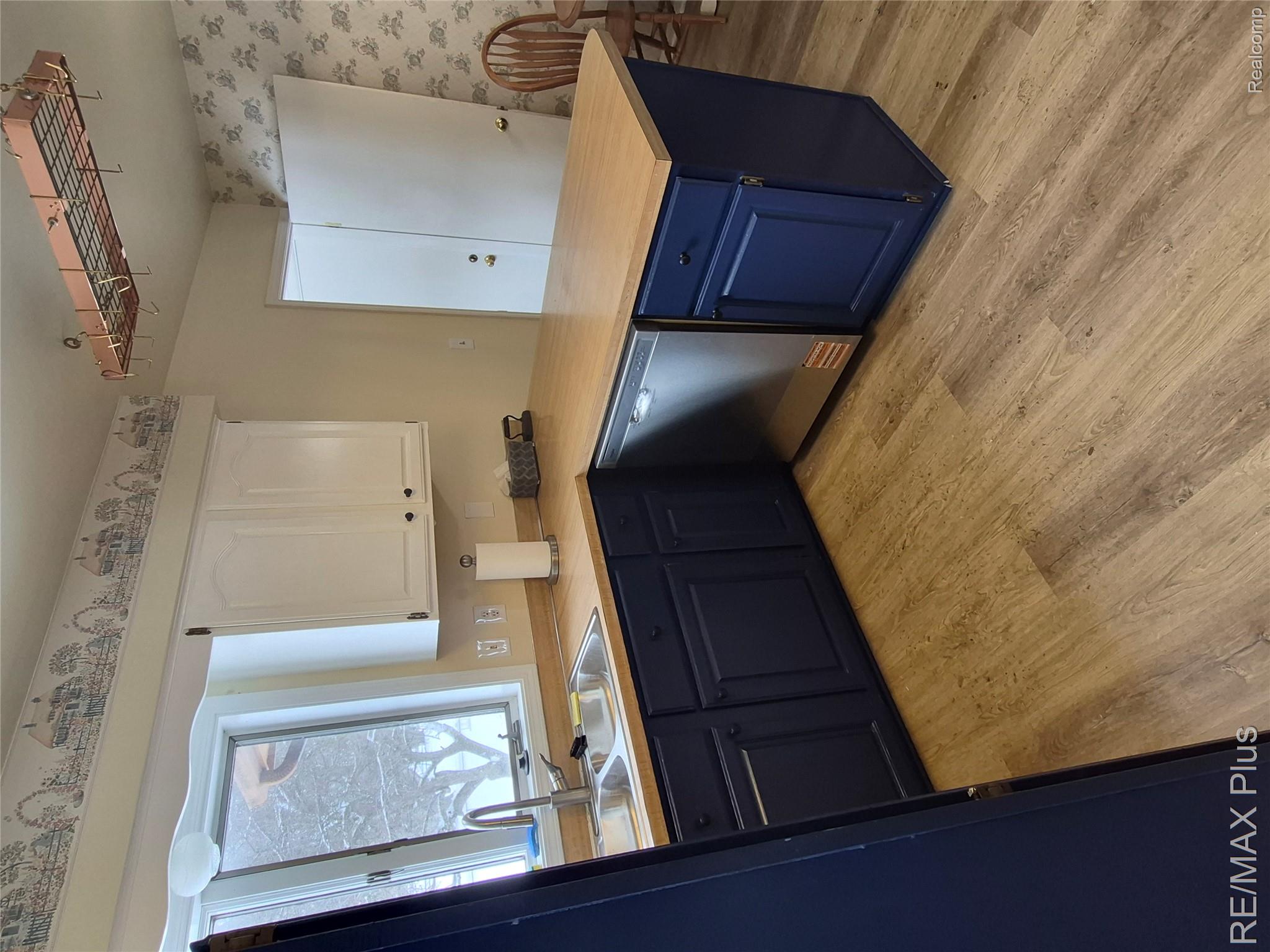 1115 Turrill Road Lapeer, MI 48446 - Photo 8 of 50 Kitchen featuring two tone cabinetry, a peninsula, light wood-style floors, stainless steel dishwasher, and light countertops