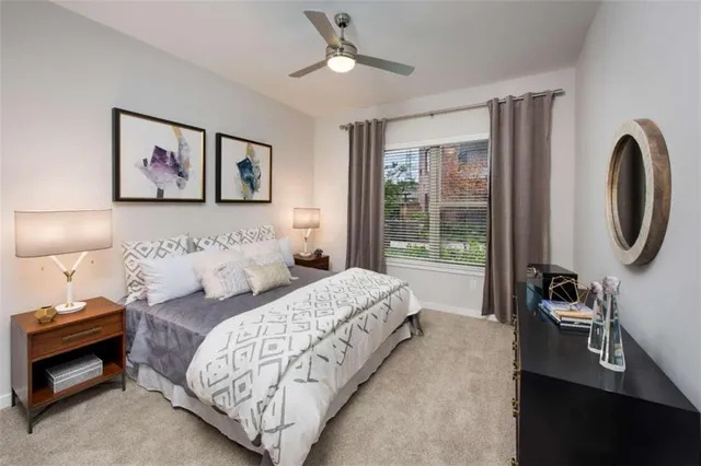 a bedroom with bed and a painting on the wall