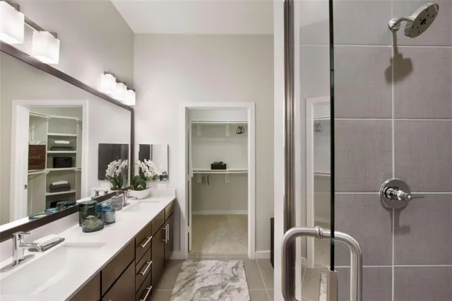 a bathroom with a double vanity sink a mirror and shower