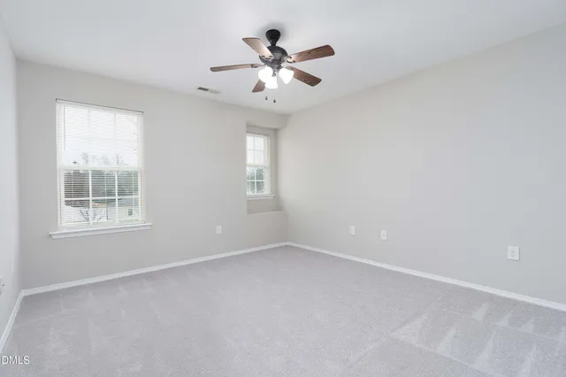 an empty room with a window and a ceiling fan