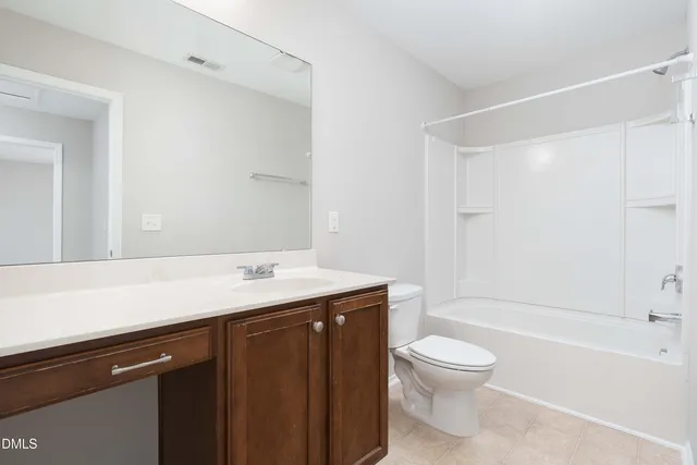 a bathroom with a granite countertop sink toilet a mirror and shower
