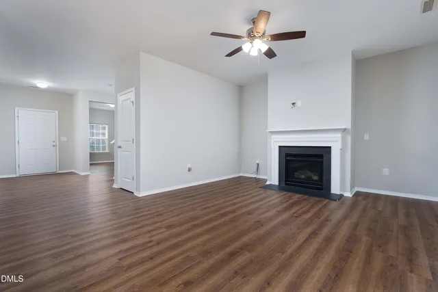 a view of empty room with wooden floor and fireplace