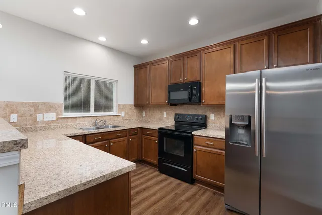 a kitchen with stainless steel appliances granite countertop a refrigerator stove microwave and sink