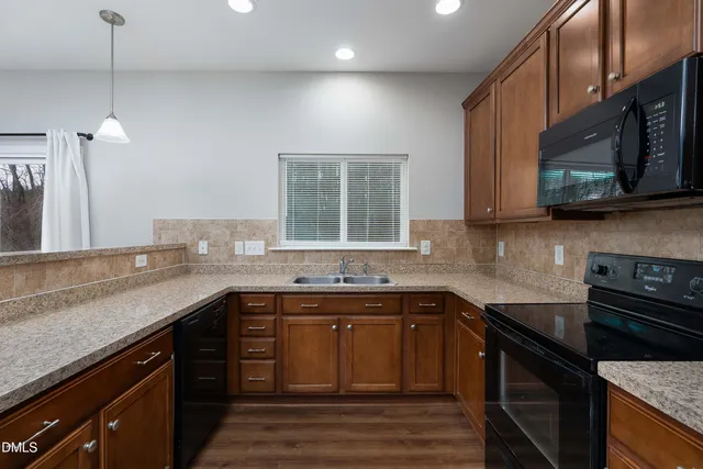 a kitchen with stainless steel appliances granite countertop a sink stove and microwave