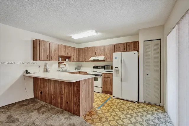 a kitchen with a sink a refrigerator and cabinets