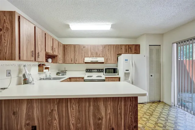a kitchen with a sink a refrigerator and cabinets