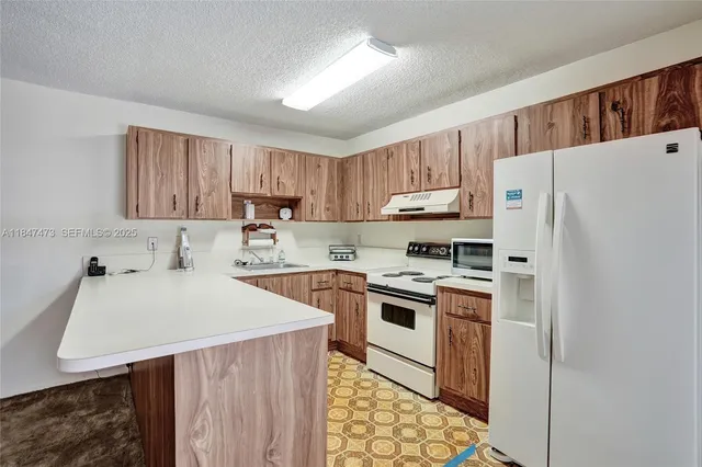 a kitchen with a white stove top oven and refrigerator