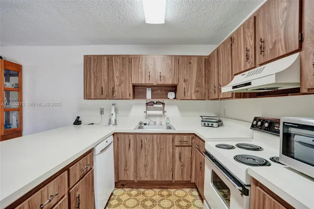 a kitchen with a sink a stove and cabinets