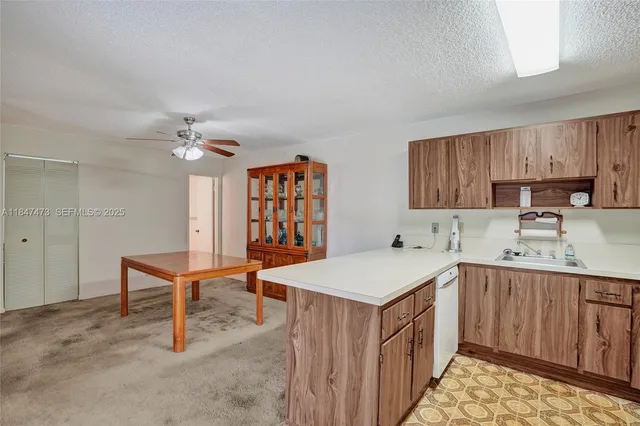 a kitchen that has a sink and chairs in it