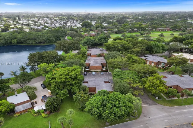 an aerial view of a house with a garden and lake view