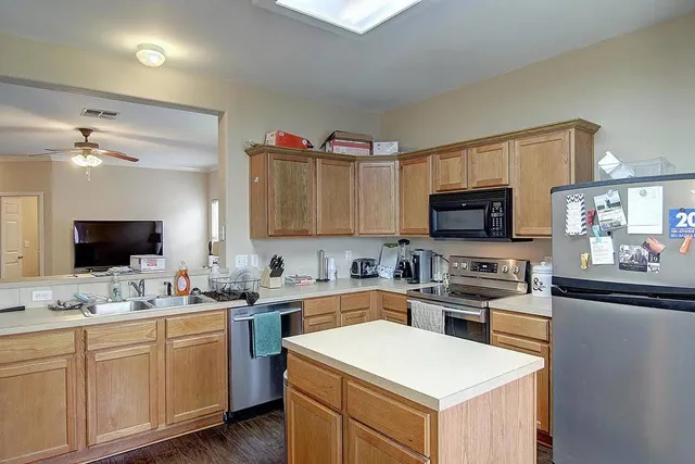 a kitchen with appliances a sink and cabinets