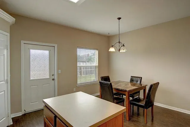 a view of a dining room with a table and chairs