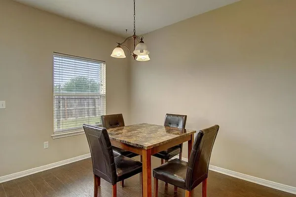 a view of a dining room with a table and chairs