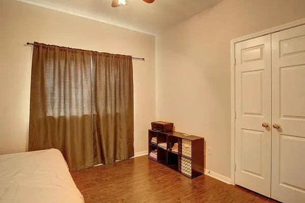 a bed sitting in a spacious bedroom next to a window