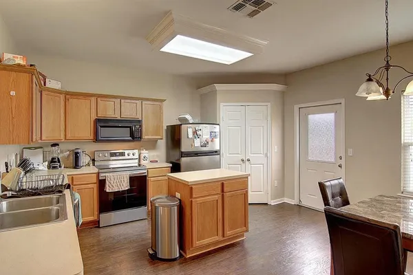 a room with furniture a sink a window and stainless steel appliances