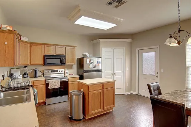 a room with furniture a sink a window and stainless steel appliances