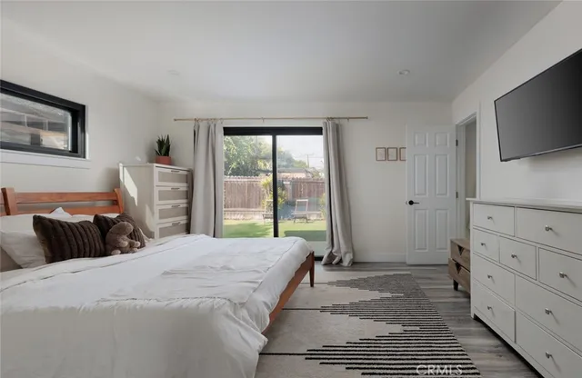 a bedroom with a large bed and a flat tv screen on dresser
