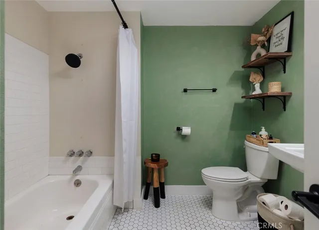 a white toilet sitting next to a bathroom sink and tub