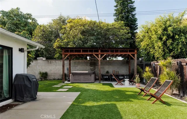 a view of a chair and table in backyard of the house