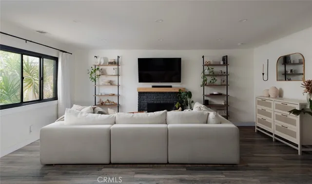 a living room with furniture a flat screen tv and a fireplace