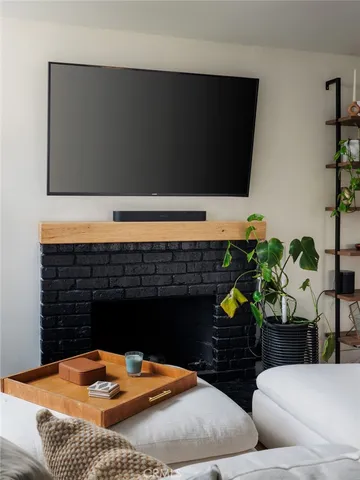 a living room with fireplace furniture and a potted plant