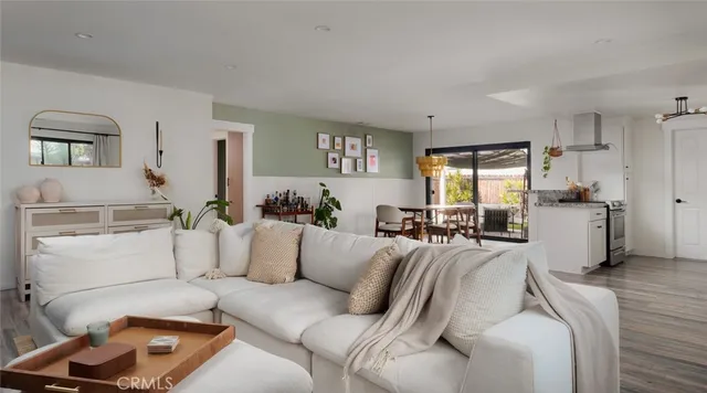 a living room with furniture and a refrigerator