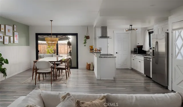 a kitchen with stainless steel appliances kitchen island granite countertop a table chairs refrigerator and sink