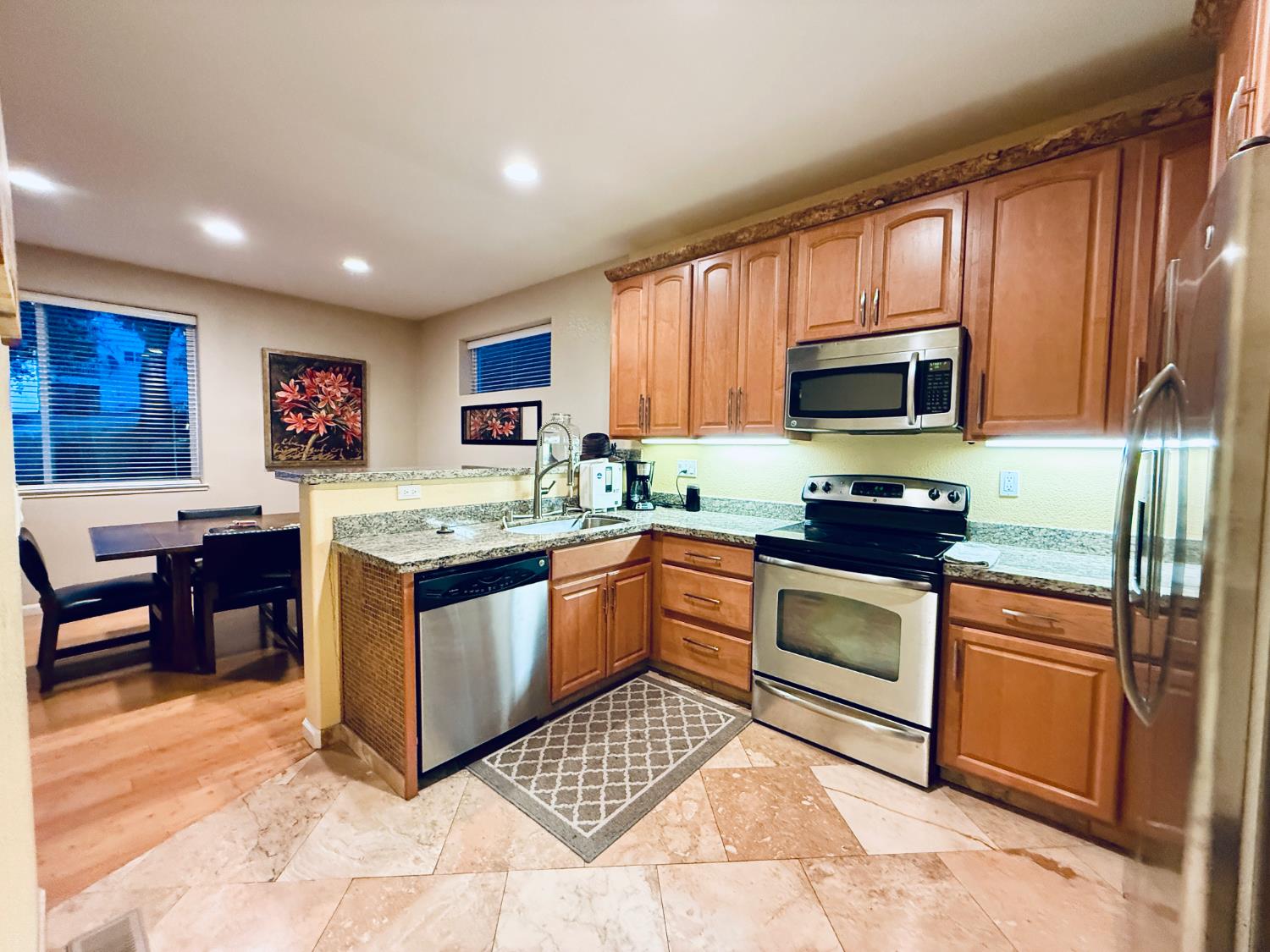 611 Sunrise Road Copperopolis, CA 95228 - Photo 3 of 29 a kitchen with stainless steel appliances granite countertop a stove top oven a sink dishwasher a dining table and chairs with wooden floor