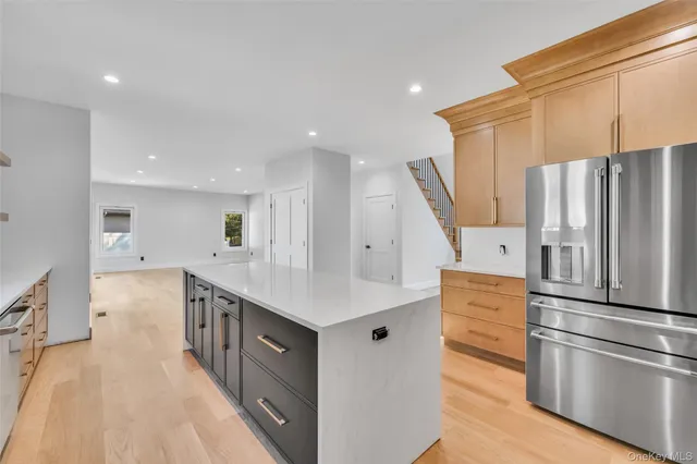 a kitchen with stainless steel appliances a refrigerator and a wooden floor