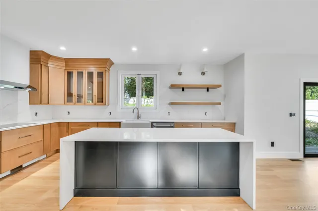 a large kitchen with stainless steel appliances a large counter top a stove and a refrigerator