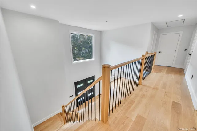 a view of a hallway with wooden floor and stairs