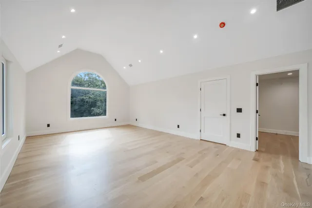 an empty room with wooden floor and window