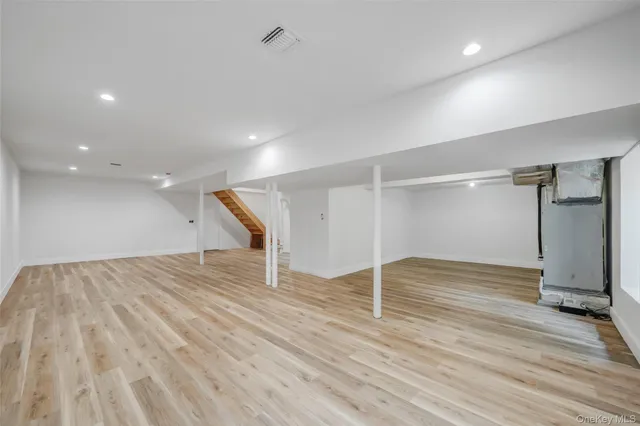 an empty room with wooden floor and a hallway