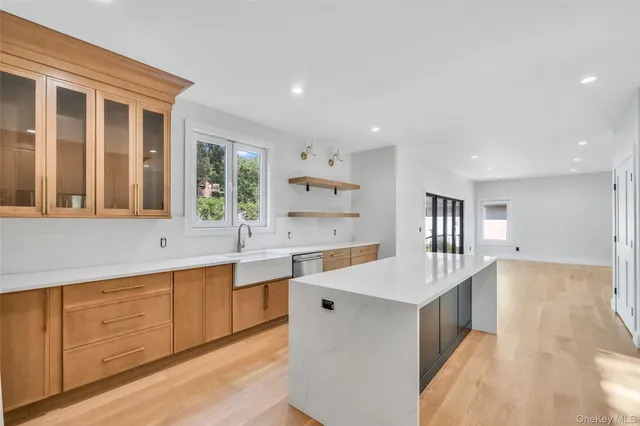 a large white kitchen with wooden floor and a sink