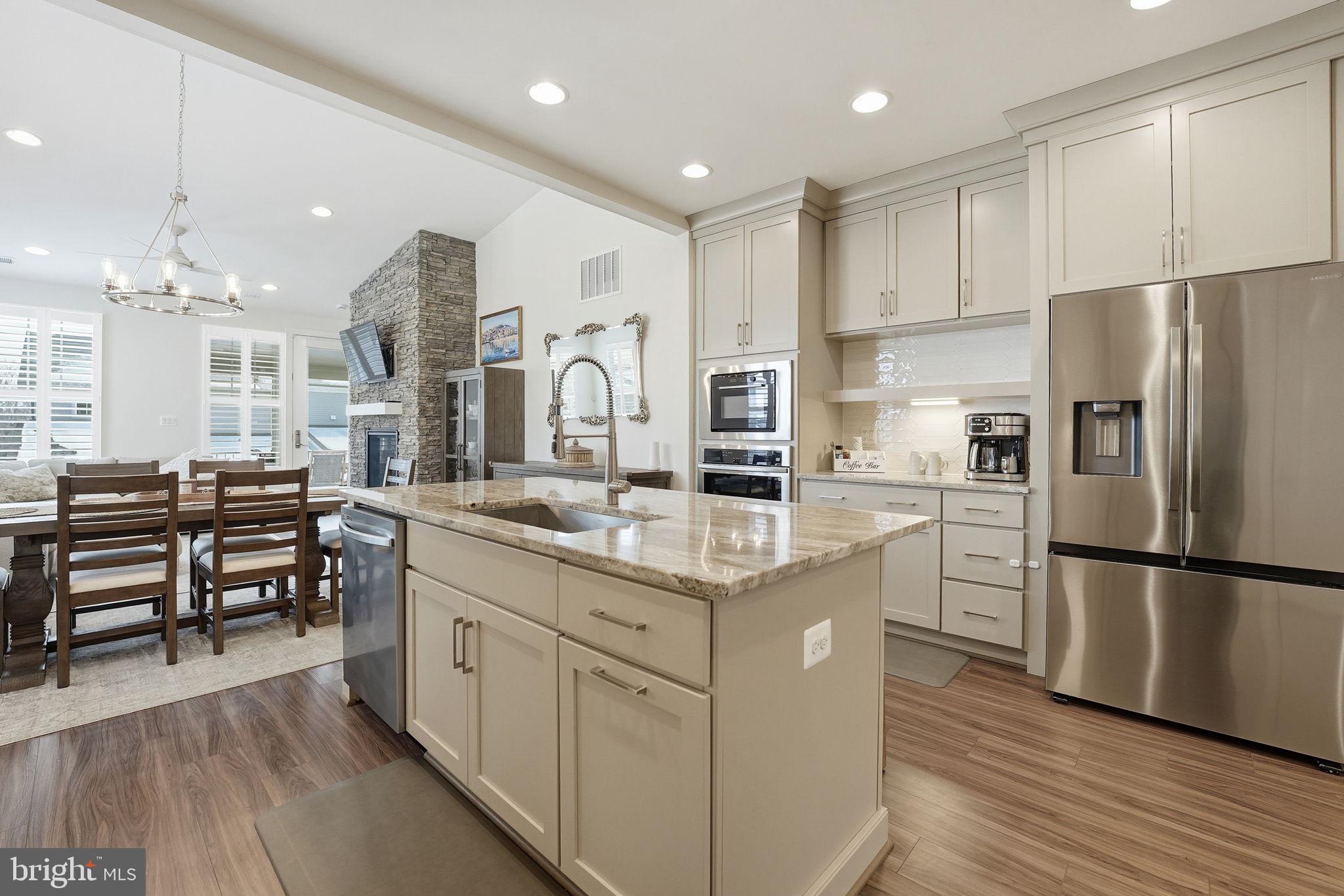 151 Windflower Way Stafford, VA 22554 - Photo 11 of 88 a kitchen with stainless steel appliances granite countertop a refrigerator a sink dishwasher a stove and white cabinets with wooden floor