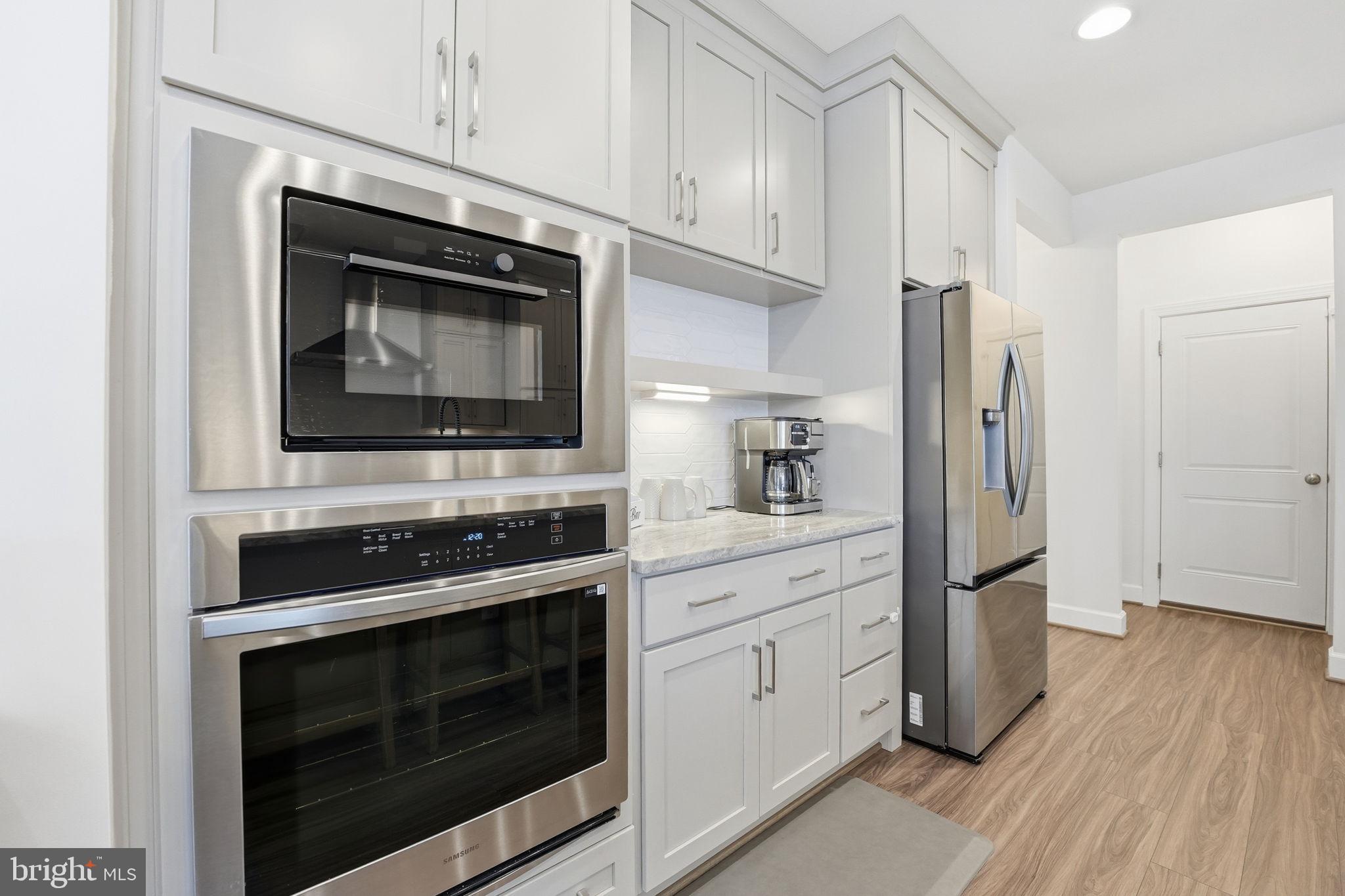 151 Windflower Way Stafford, VA 22554 - Photo 12 of 88 a kitchen with stainless steel appliances white cabinets white stove and a refrigerator