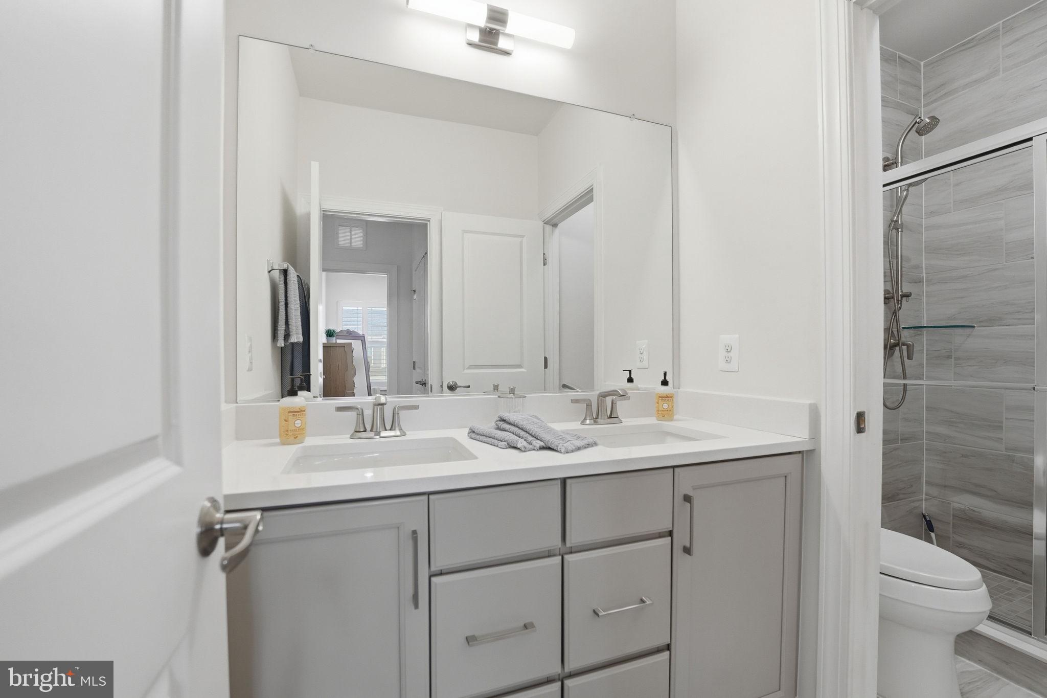 151 Windflower Way Stafford, VA 22554 - Photo 41 of 88 a bathroom with a double vanity sink toilet and a mirror