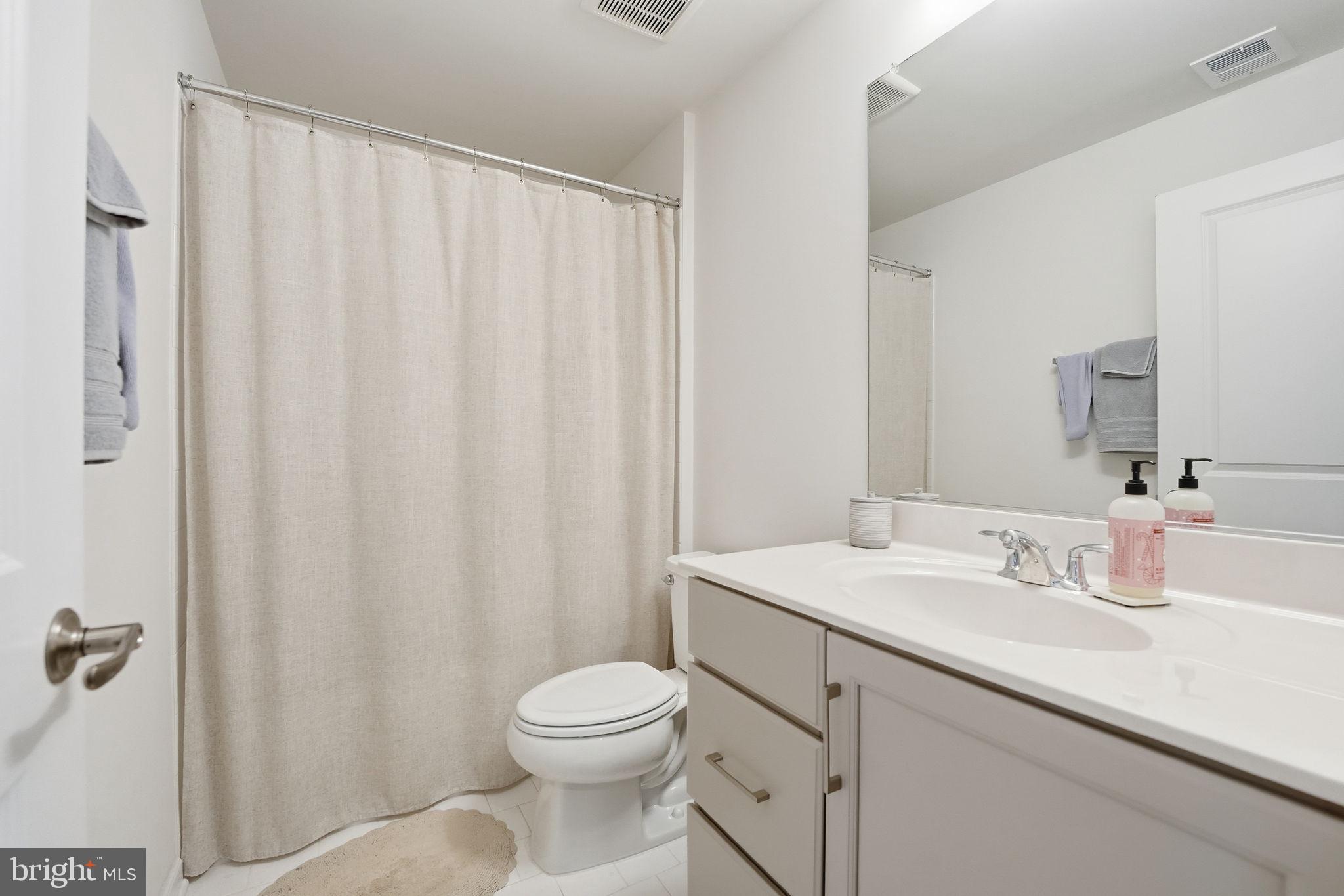151 Windflower Way Stafford, VA 22554 - Photo 48 of 88 a bathroom with a sink a toilet and shower curtain