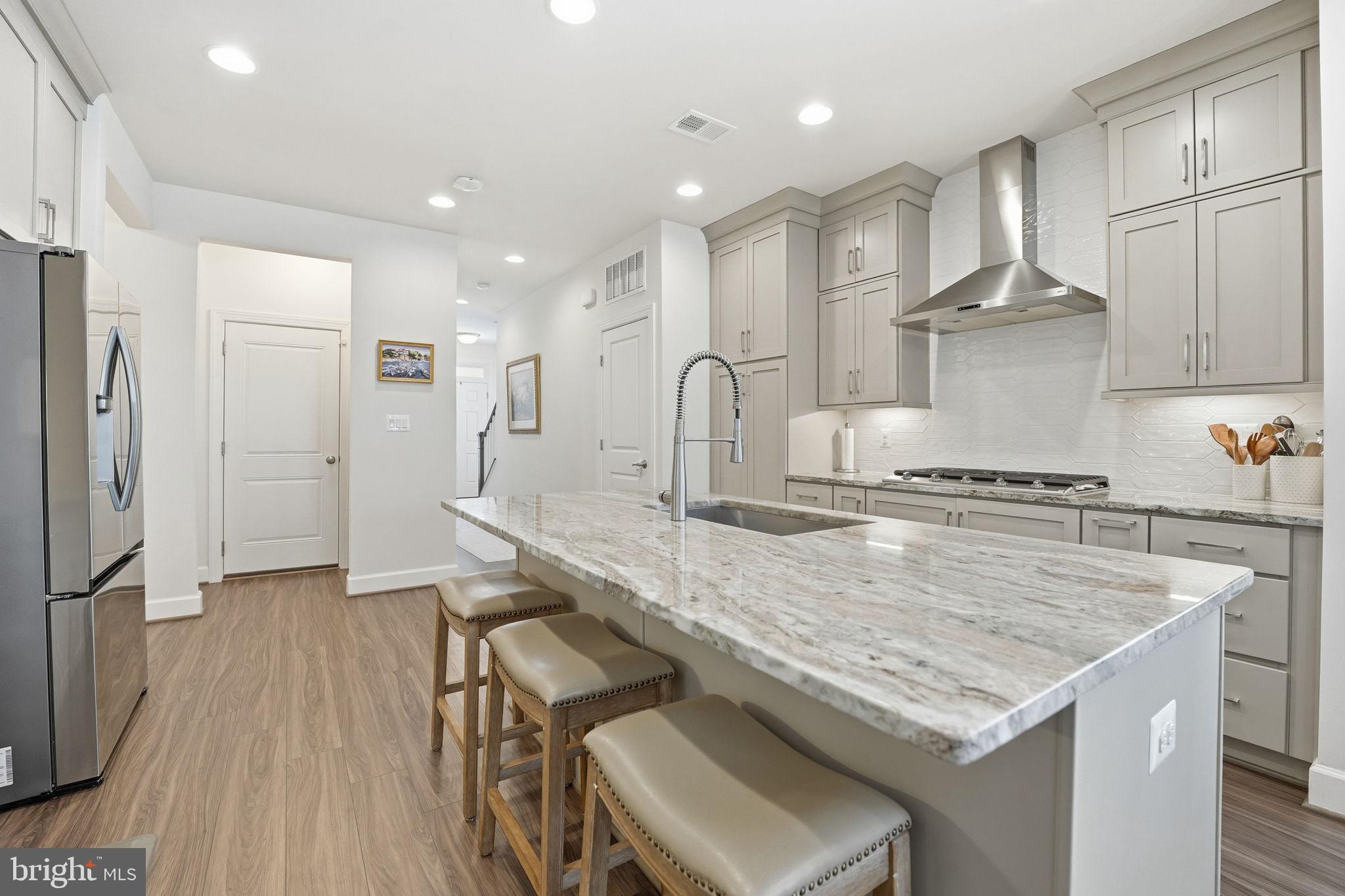 151 Windflower Way Stafford, VA 22554 - Photo 7 of 88 a kitchen with stainless steel appliances granite countertop a kitchen island a stove a refrigerator a sink and a refrigerator