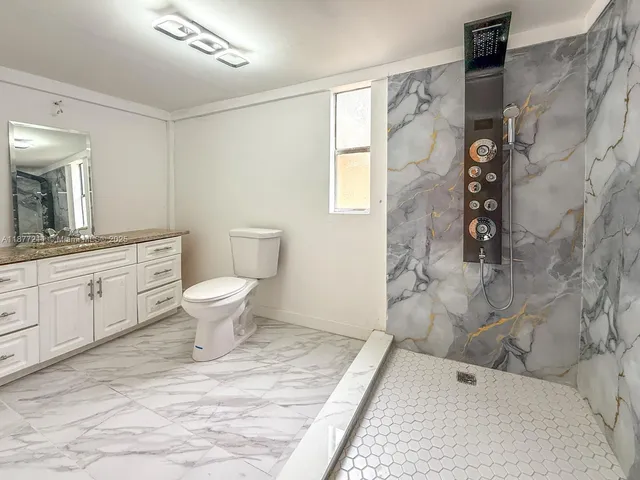 a bathroom with a toilet and a shower