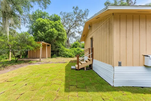 a view of a house with backyard and wooden fence