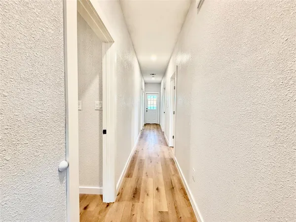 a view of a hallway with wooden floor