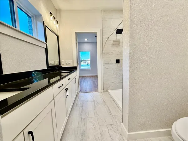 a bathroom with a granite countertop sink and a mirror