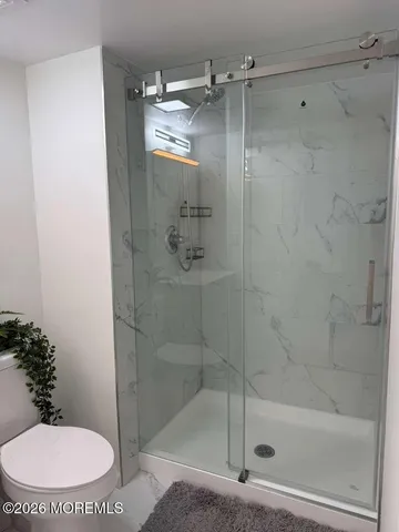 a spacious bathroom with a toilet a sink and a mirror