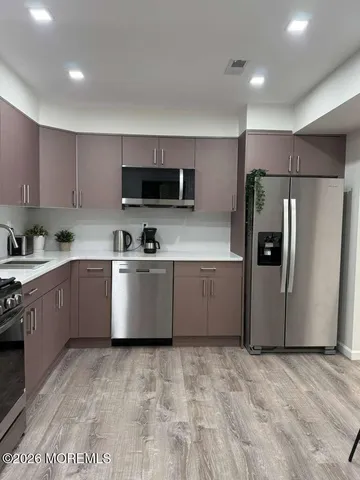 a kitchen with stainless steel appliances a refrigerator sink and microwave