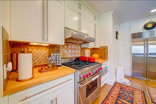 a kitchen with a stove and a white cabinets