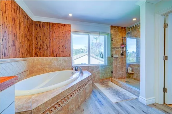 a bathroom with a granite countertop sink a bathtub and next to a window