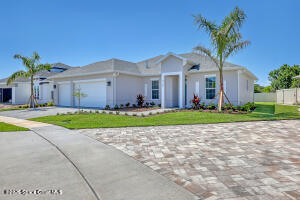 4195 Negal Circle Melbourne, FL 32901 - Photo 2 of 17 a view of a white house with a big yard and potted plants